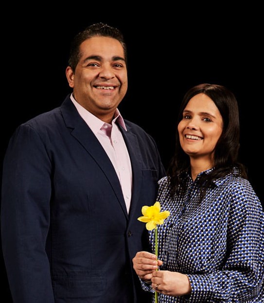 Harjeet standing next to her husband, holding a daffodil