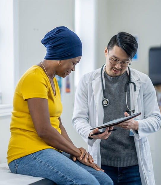 A doctor looks at a document with their patient.