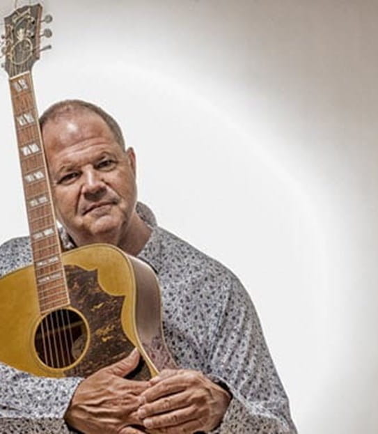 Jeff tenant une guitare acoustique