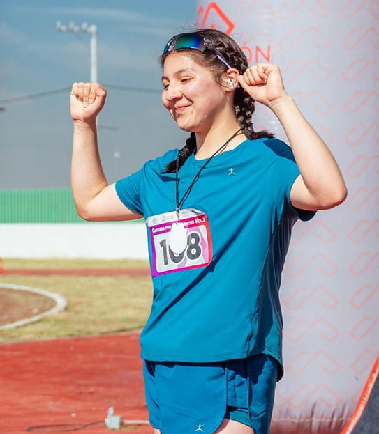 A woman in sportswear raising her arms in celebration