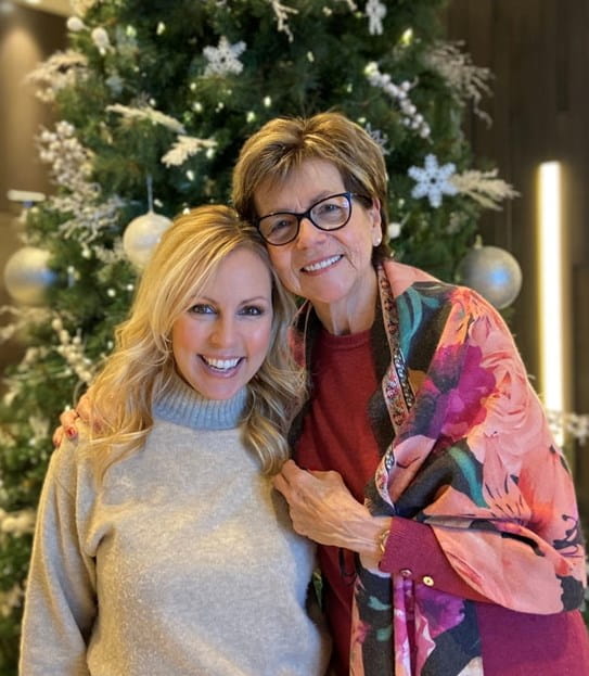Emilie Cerretti and her mother standing in front of a Christmas tree