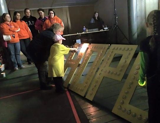 Hailey and her mother lighting candles in the shape of the word ‘hope.’