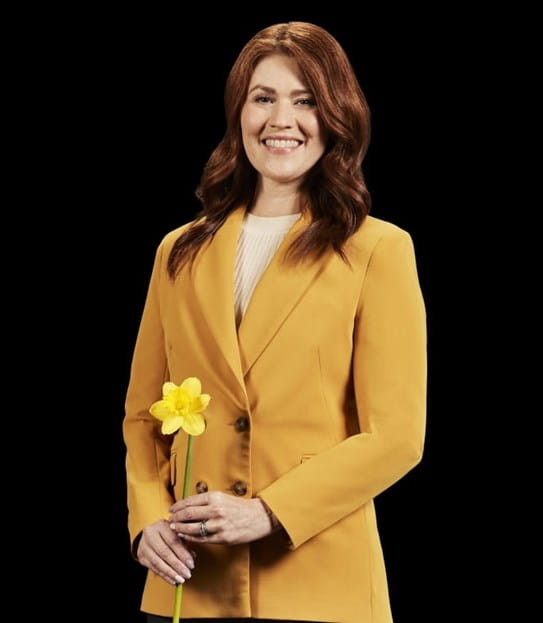 Cassidy London, souriant, une jonquille à la main.