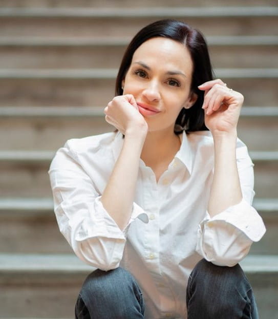 Vanessa Percoco, assise sur des marches et souriante