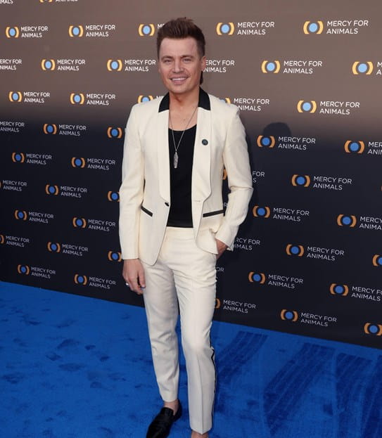 Shawn Hook posing on carpet in front of a wall that says 'Mercy for Animals.'
