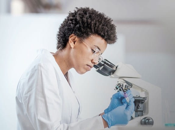 Woman looks through a microscope