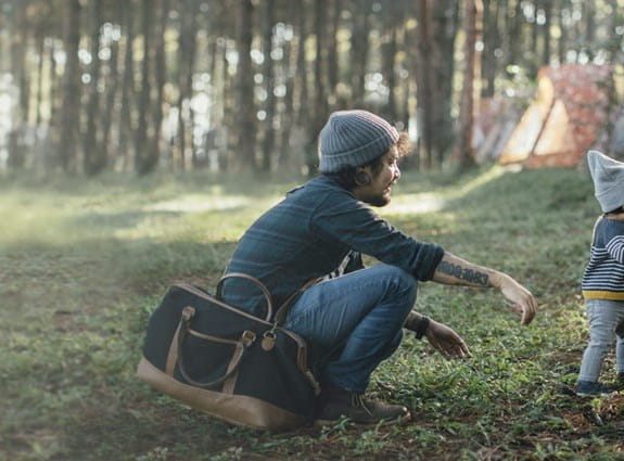 Une jeune famille à l’extérieur avec leur enfant